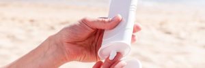 Person putting sunscreen on their hands at the beach