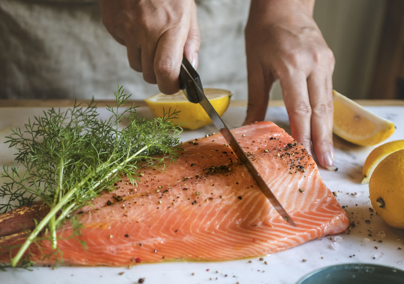man cutting and preparing his fresh fish to eat 