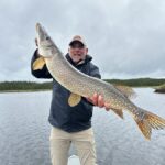 man getting his picture taken holding his trophy catch