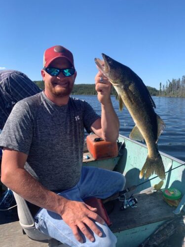 Man Holding Fish caught in Reindeer Lake